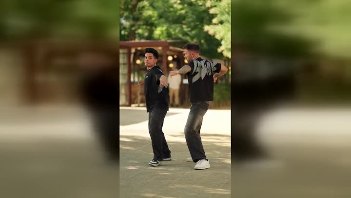 Dos personas en movimiento en un parque, grabadas en formato vertical